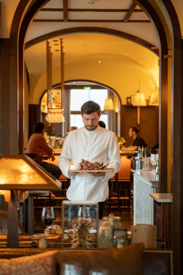 Head chef serving a Tomahawk in the dining room